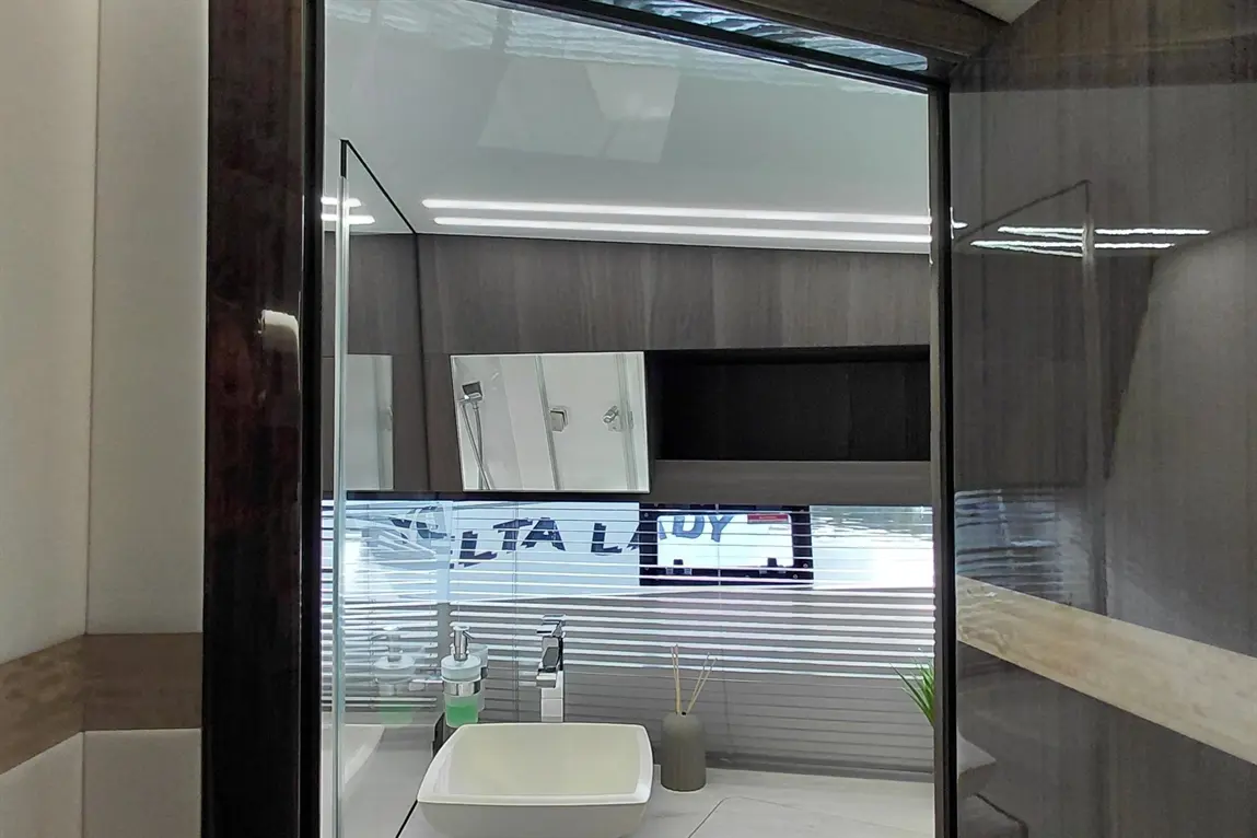 Modern bathroom interior featuring a sink, mirrors, and minimalist decor with green accents and ambient lighting.